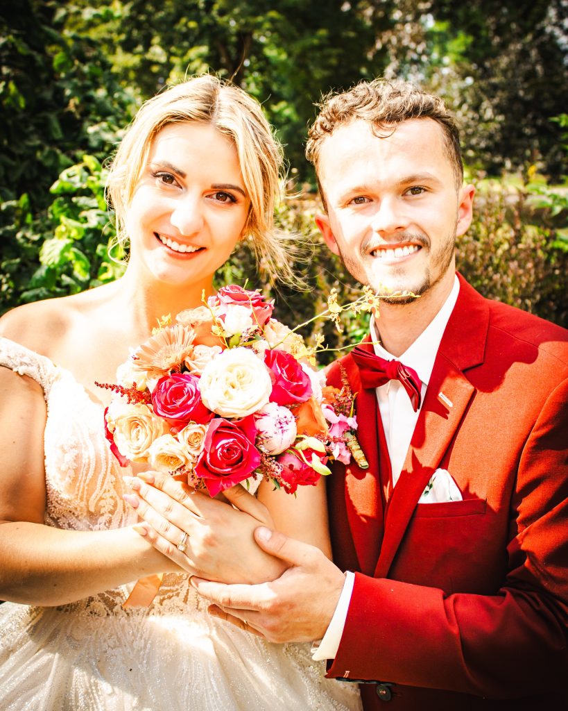 Portrait des mariés tenant le bouquet lors d’une séance photo de mariage en extérieur.