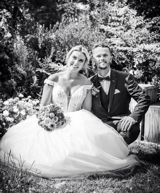 Couple de mariés posant ensemble en extérieur, lors d’une séance photo de mariage.