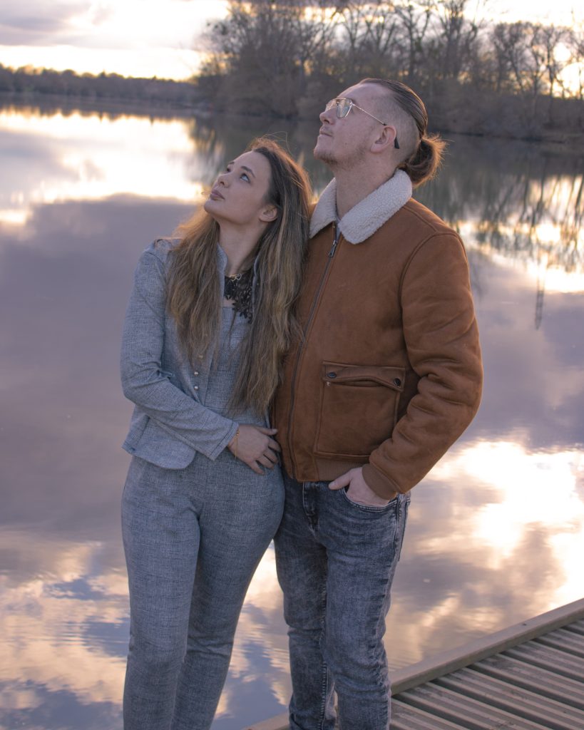 Couple marchant ensemble en extérieur, tenue décontractée, lumière douce de fin de journée.