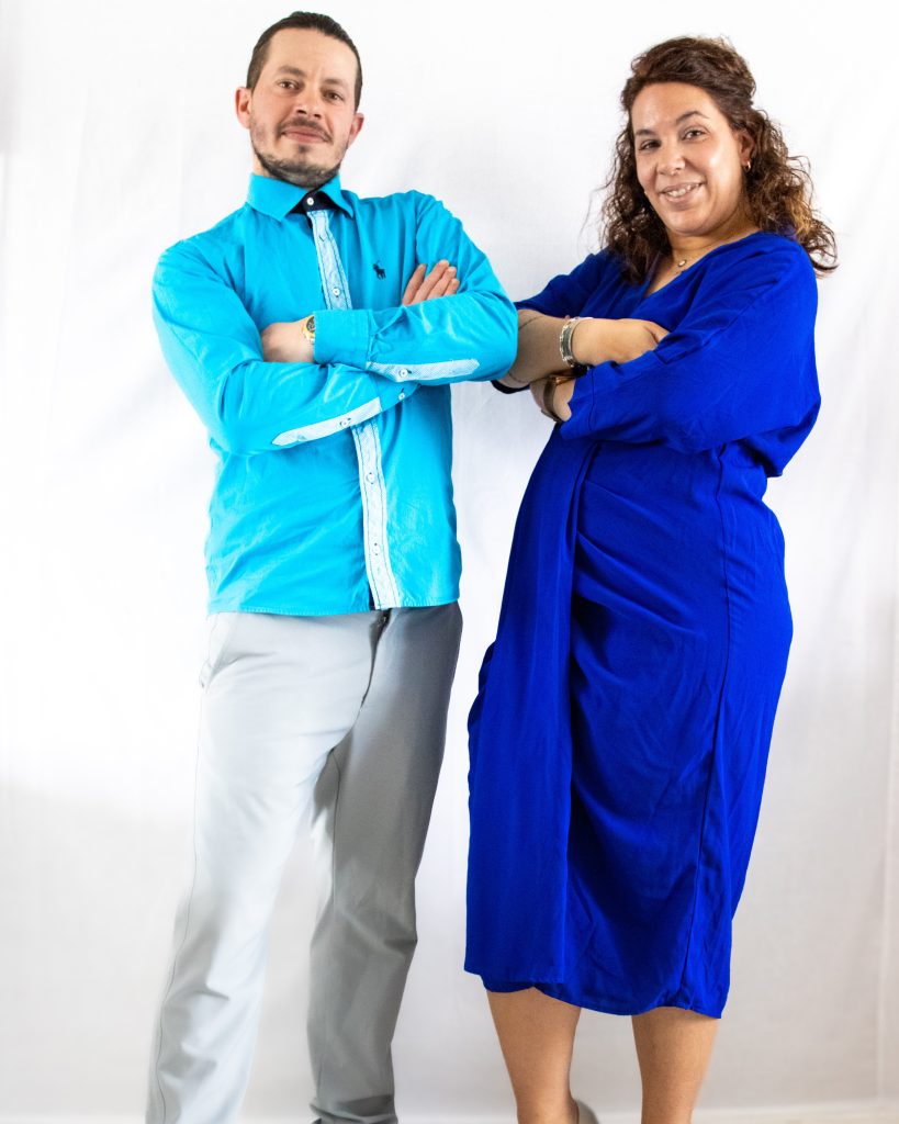Portrait de deux personnes posant bras croisés en studio, sur fond blanc.