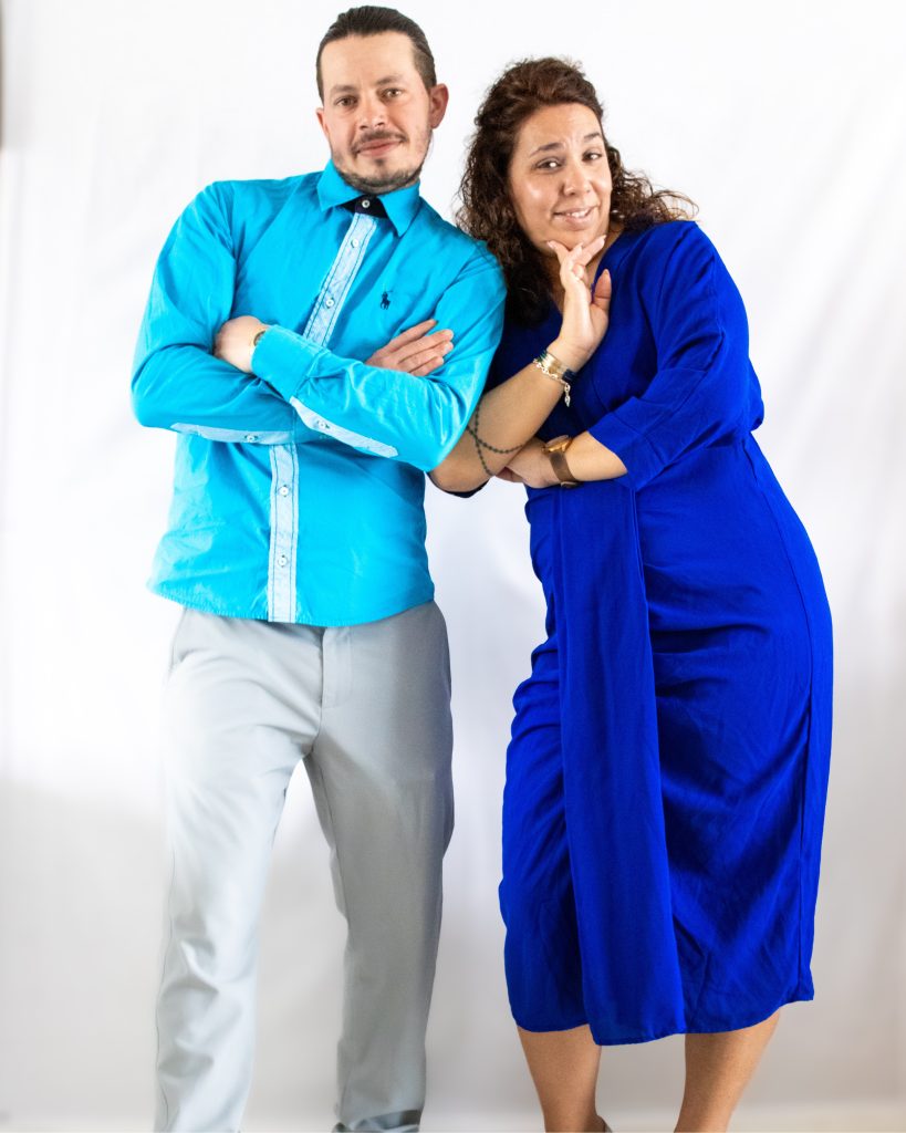 Portrait de deux personnes posant ensemble en studio, dans une ambiance dynamique et colorée.