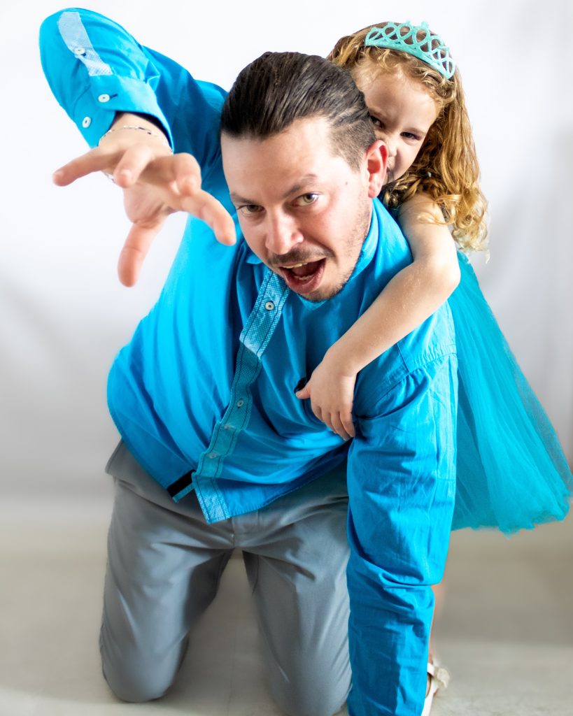 Père et fille jouant ensemble et riant lors d’une séance photo dynamique.