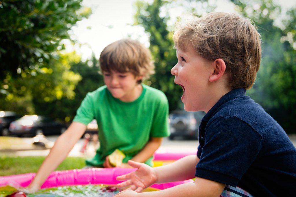 Enfants jouant ensemble en extérieur, illustrant une ambiance ludique et familiale.