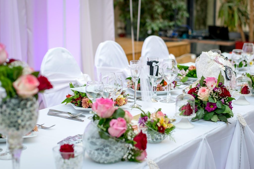Table de réception de mariage décorée avec des fleurs, verrerie et centres de table élégants.